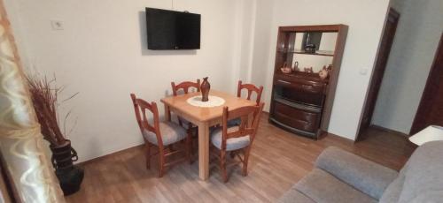 comedor con mesa, sillas y TV en Apartamento junto al Peñon de Ifach con parking, en Calpe