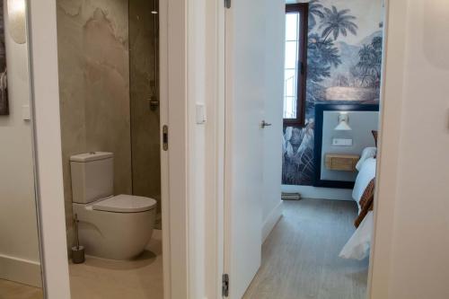 a bathroom with a toilet and a bedroom at CISNES PALACE in Sanlúcar de Barrameda