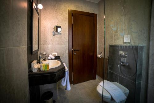 a bathroom with a sink and a shower and a toilet at Khan Khediwe Hotel in Amman