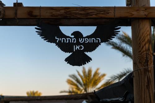a black bird flying in the sky with the words imma within at Ras Hasita in H̱aẕeva