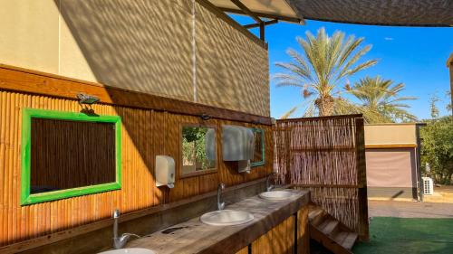 a bathroom with three sinks in a wooden wall at Ras Hasita in H̱aẕeva