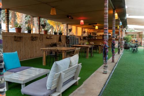 an outdoor patio with chairs and tables and grass at Ras Hasita in H̱aẕeva