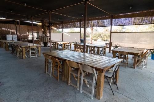a group of wooden tables and chairs in a building at Ras Hasita in H̱aẕeva