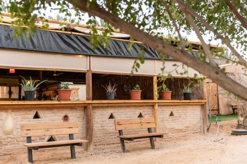 a building with two benches in front of it at Ras Hasita in H̱aẕeva