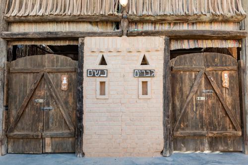 an old barn with two doors and a bird house at Ras Hasita in H̱aẕeva
