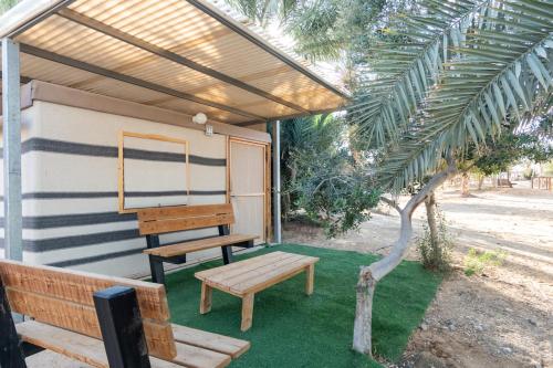 a porch with a bench and a piano at Ras Hasita in H̱aẕeva