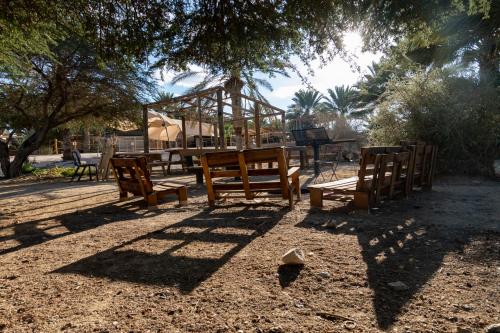 a group of benches in a park with a playground at Ras Hasita in H̱aẕeva