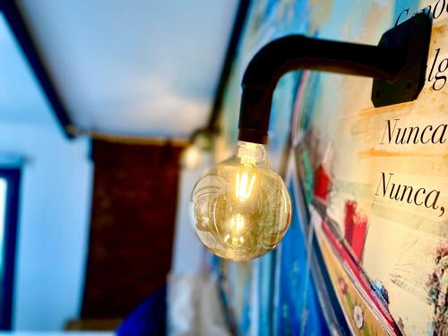 a glass bottle hanging on a wall with a wine bottle at Villa Rio by Valada Village in Valada