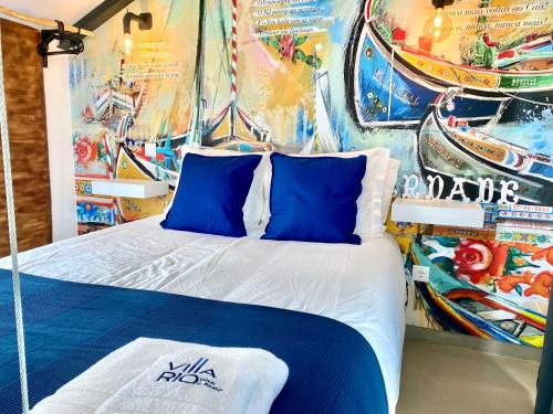 a bedroom with a bed with blue and white pillows at Villa Rio by Valada Village in Valada