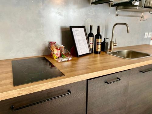 a kitchen counter with a sink and bottles of wine at Villa Rio by Valada Village in Valada