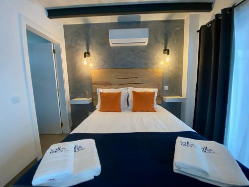 a bedroom with a blue and white bed with orange pillows at Villa Rio by Valada Village in Valada