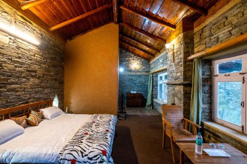 a bedroom with a large bed in a brick wall at Himalayan Paradise, Boutique room w Binsar view by Roamhome in Almora