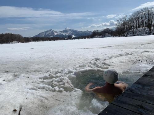 a man in a hot tub in the snow at Lakeside Hotels Kuore in Kitashiobara