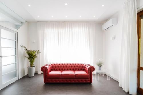 a red couch in a living room with a window at Park Hotel Giusy in Lido di Camaiore