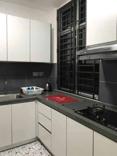 a kitchen with white cabinets and a stove top oven at Homestay SKS Apartment Larkin Johor Bahru in Johor Bahru