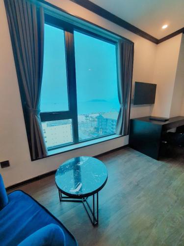 a living room with a glass table and a large window at Kingdom Hotel Cua Lo in Cửa Lò