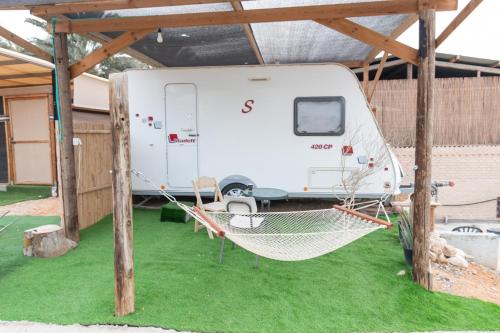 a white trailer parked in a tent at Ras Hasita in H̱aẕeva