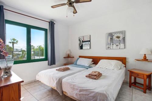 a bedroom with two beds and a window at Jardin del Sol 30 in Playa Blanca