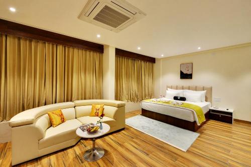 a hotel room with a bed and a couch at Mastiff Select Gulbarga Hotel in Gulbarga
