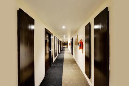 a hallway with black and white walls and black doors at Mastiff Select Gulbarga Hotel in Gulbarga