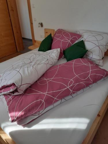 a bed with purple and white pillows on it at Ferienhaus Weitblick in Flachau