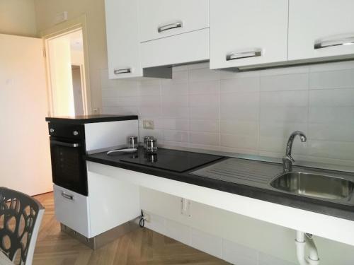 a kitchen with a sink and a counter top at Il Giglio Marino Cilento Residence by ElodeaGroup in Ascea