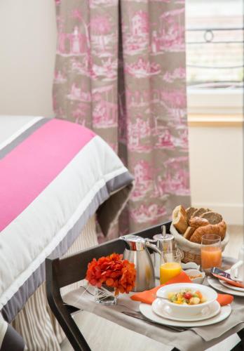 bandeja de desayuno en una mesa con cama en Relais des Trois Châteaux Hôtel-Restaurant - Teritoria, en Cour-Cheverny