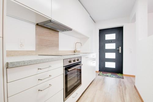 a kitchen with white cabinets and a sink at Bijou in Selma
