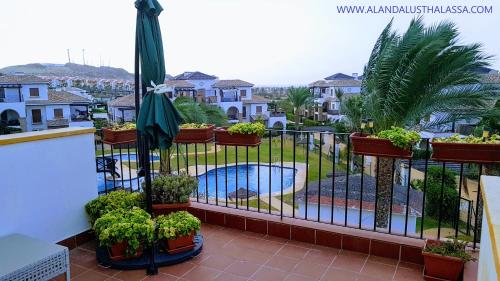 un balcon avec des plantes en pot et une piscine dans l'établissement Al Andalus Thalassa III VERARENTAL-COM, à Vera
