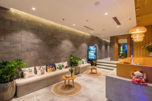 a lobby with couches and potted plants at Kua Casa Suite in Da Nang