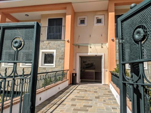 a house with a gate and a walkway at Il Giglio Marino Cilento Residence by ElodeaGroup in Ascea
