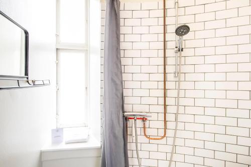 a bathroom with a shower with a shower curtain at The Mile 1 by Daniel&Jacob's in Copenhagen