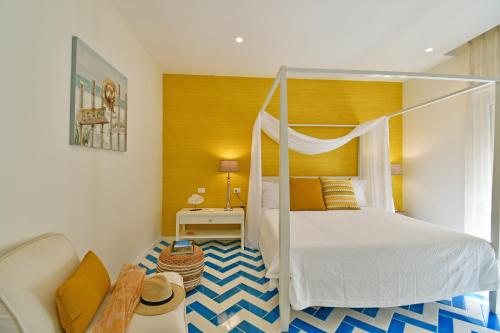 - une chambre avec un lit à baldaquin et un canapé dans l'établissement Luxury Suites Casa di Joy in Cefalù, à Cefalù
