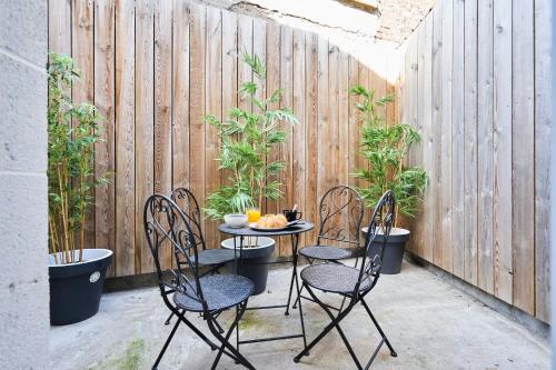 d'une terrasse avec une table, des chaises et une clôture. dans l'établissement Beautiful house at the heart of Lomme nearby Lille center - Welkeys, à Lille