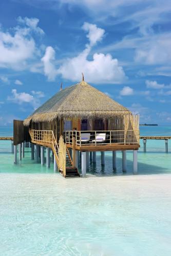 a hut on a beach in the water at Constance Moofushi Maldives - All Inclusive in Himandhoo 