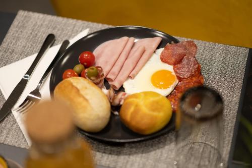 a plate of breakfast food with eggs sausage and bread at SAVOY residence in Osijek