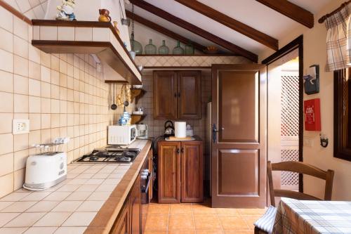 a kitchen with a stove and a counter top at Live Casa Rural El Cango in La Degollada