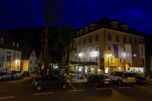 a city street with cars parked in front of a building at Akzent Hotel Goldner Stern in Muggendorf
