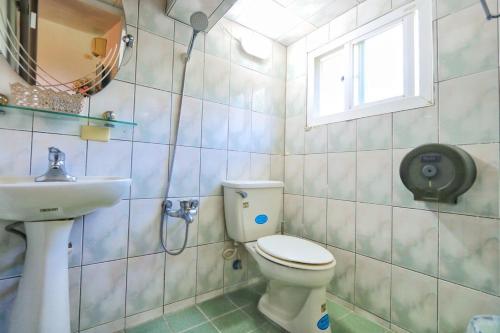un bagno con un water, un lavandino e una finestra di 龍坑民宿 a Eluan