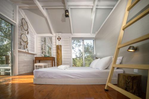 sypialnia z łóżkiem i dużym oknem w obiekcie FairyTale w mieście Koukounariá