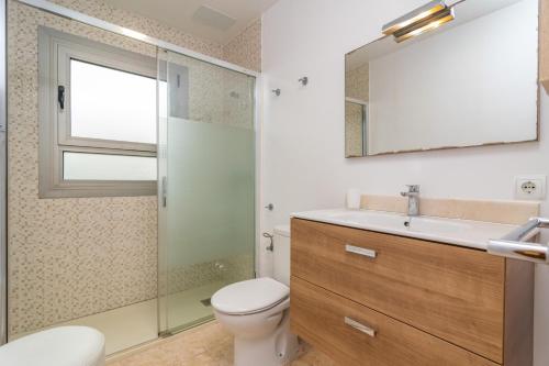 a bathroom with a toilet and a sink and a mirror at Violeta de Mar in Playa de Muro