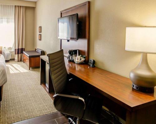 a hotel room with a desk with a television at Comfort Suites Georgetown in Georgetown