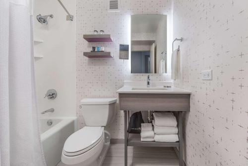 a bathroom with a toilet, sink, and bathtub at Sonesta Denver Downtown in Denver