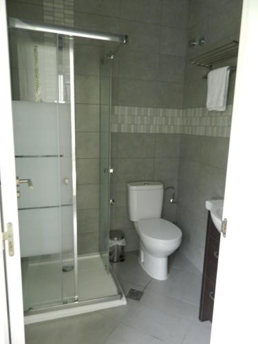 a bathroom with a toilet and a glass shower at Hotel Restaurant Baladrar in Benissa