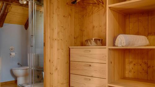 baño con aseo y pared de madera en Saplan Real Estate VILAMOS, en Vilamòs