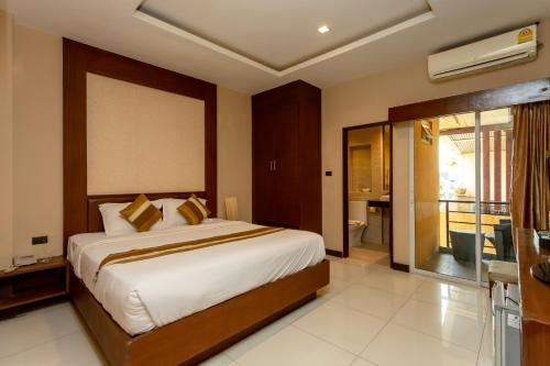 a bedroom with a large bed and a balcony at Honey Inn Pattaya in Pattaya Central
