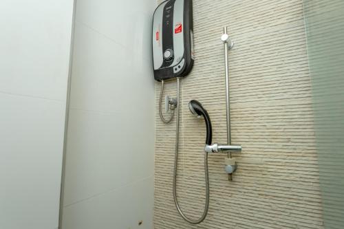 a cell phone hanging on a wall with a shower at Honey Inn Pattaya in Pattaya Central