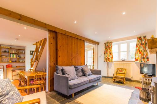 a living room with a couch and a tv at Marlpit Cottage - Norfolk Holiday Properties in Salthouse