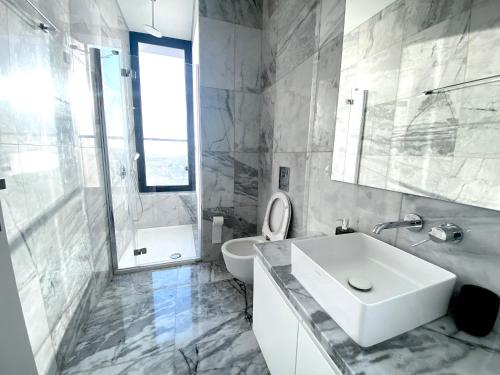 Baño blanco con lavabo y aseo en Luxury Private Apartments - Limassol, en Limassol