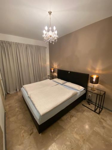 a bedroom with a large bed and a chandelier at Lago Maggiore- Casa Roccia-Ferienwohnung in Pino sulla Sponda in Pino Lago Maggiore